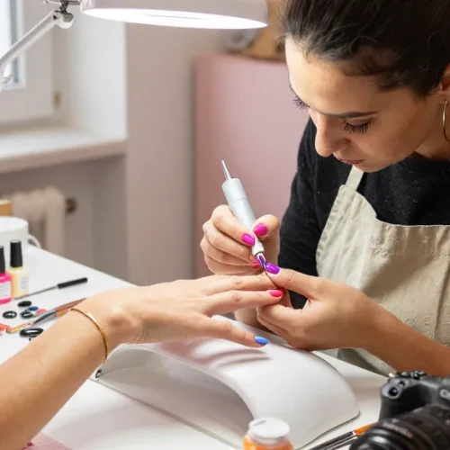 Aplicarea gelului pentru constructie unghii într-un salon de unghii vibrant, cu produse colorate și lumină naturală.